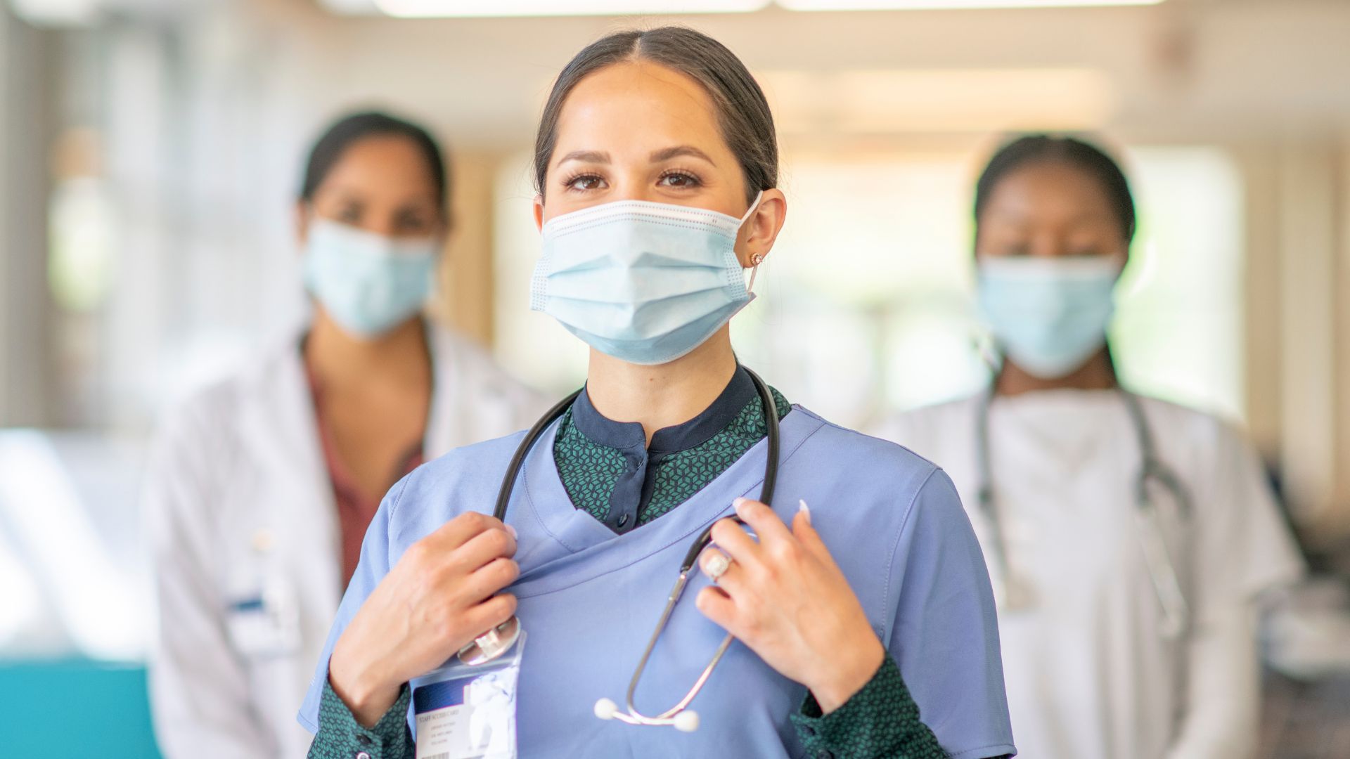 A nurse in the forefront with two nurses in the background