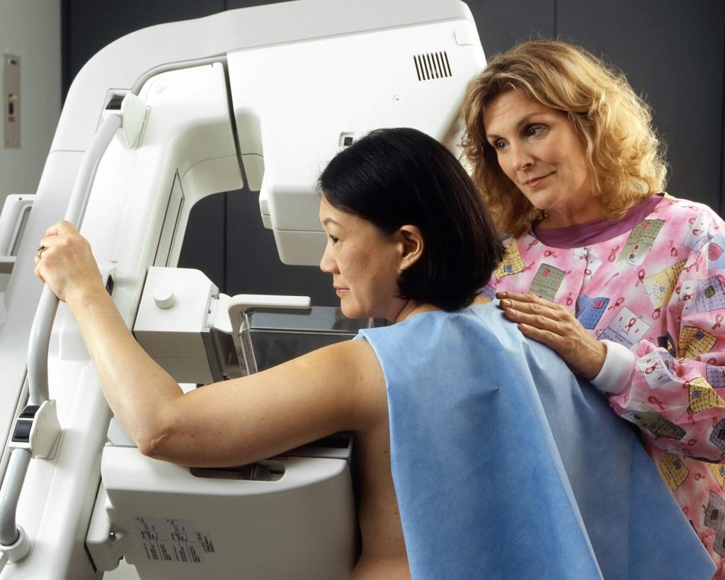 Mammogram scan in progress with medical support