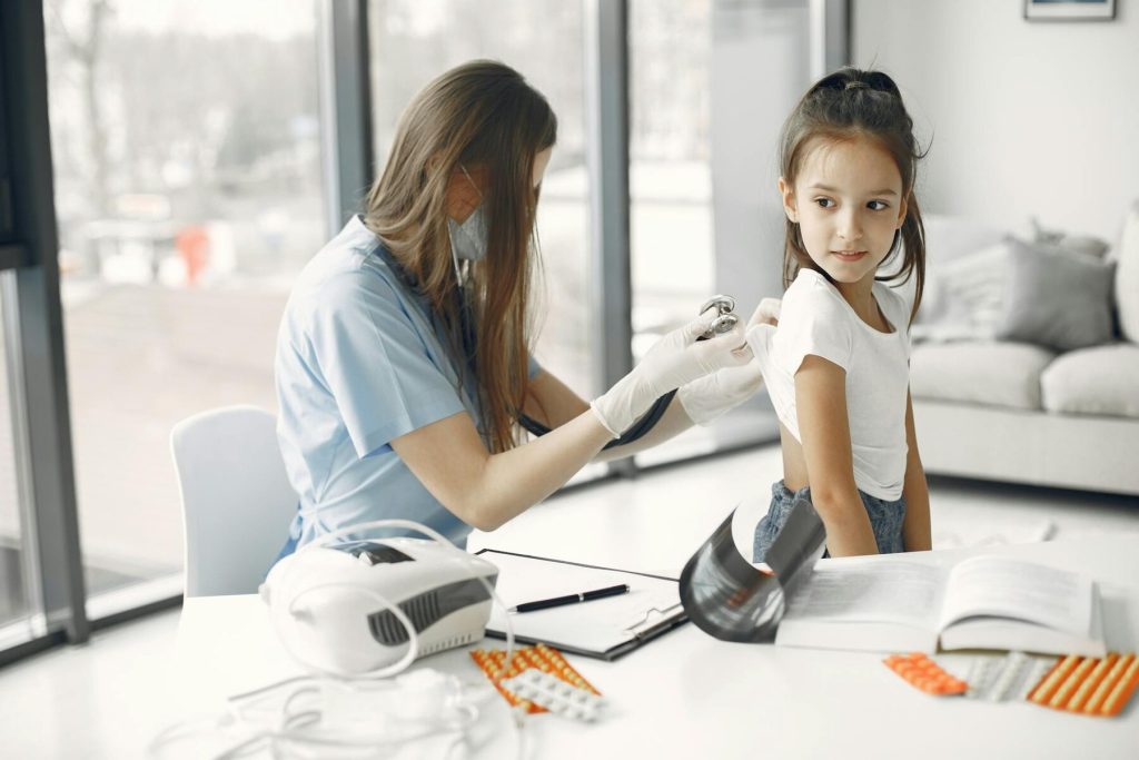A nurse listens to a child's heartbeat with a stethoscope
