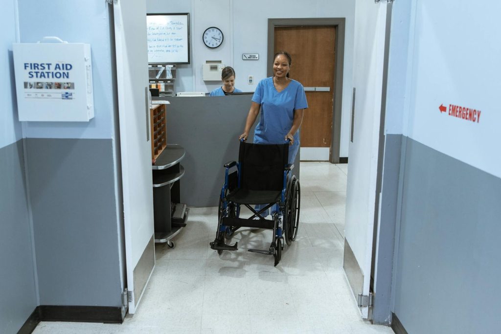Nurse pushing a wheelchair down a hospital hallway