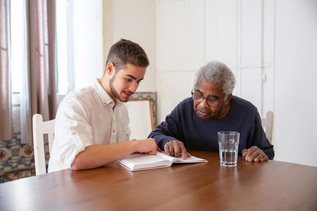 A healthcare staff assisting his patient reading
