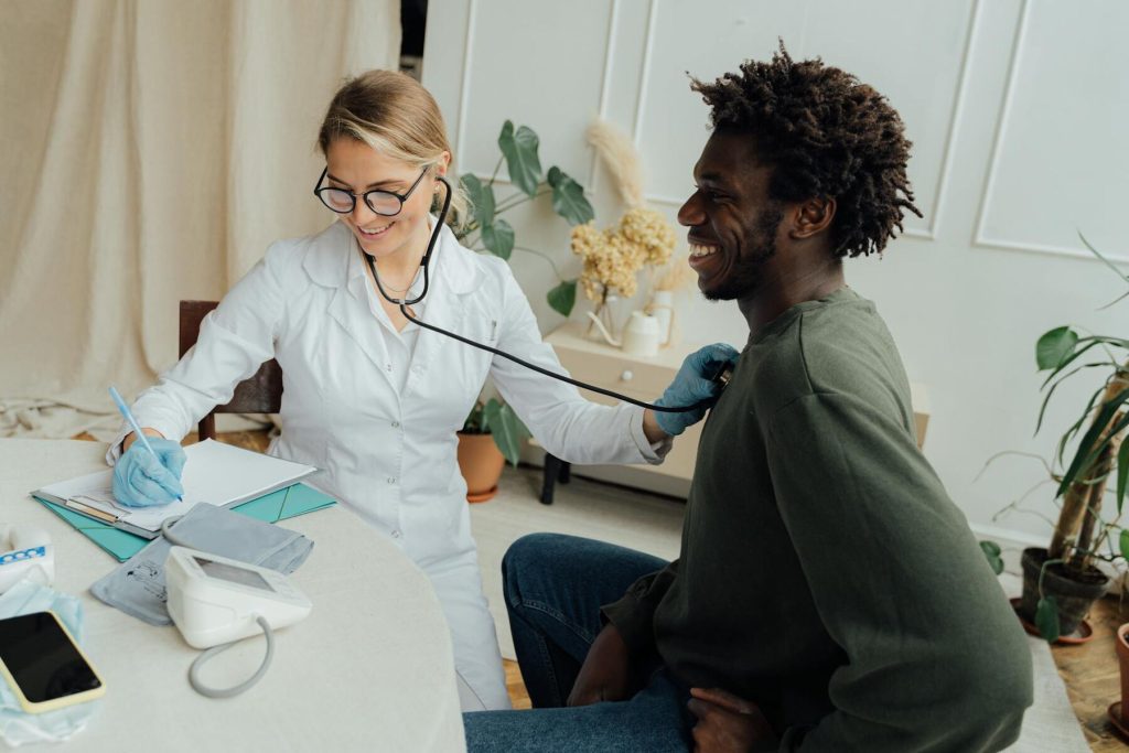 A doctor taking notes while performing a check-up on a patient