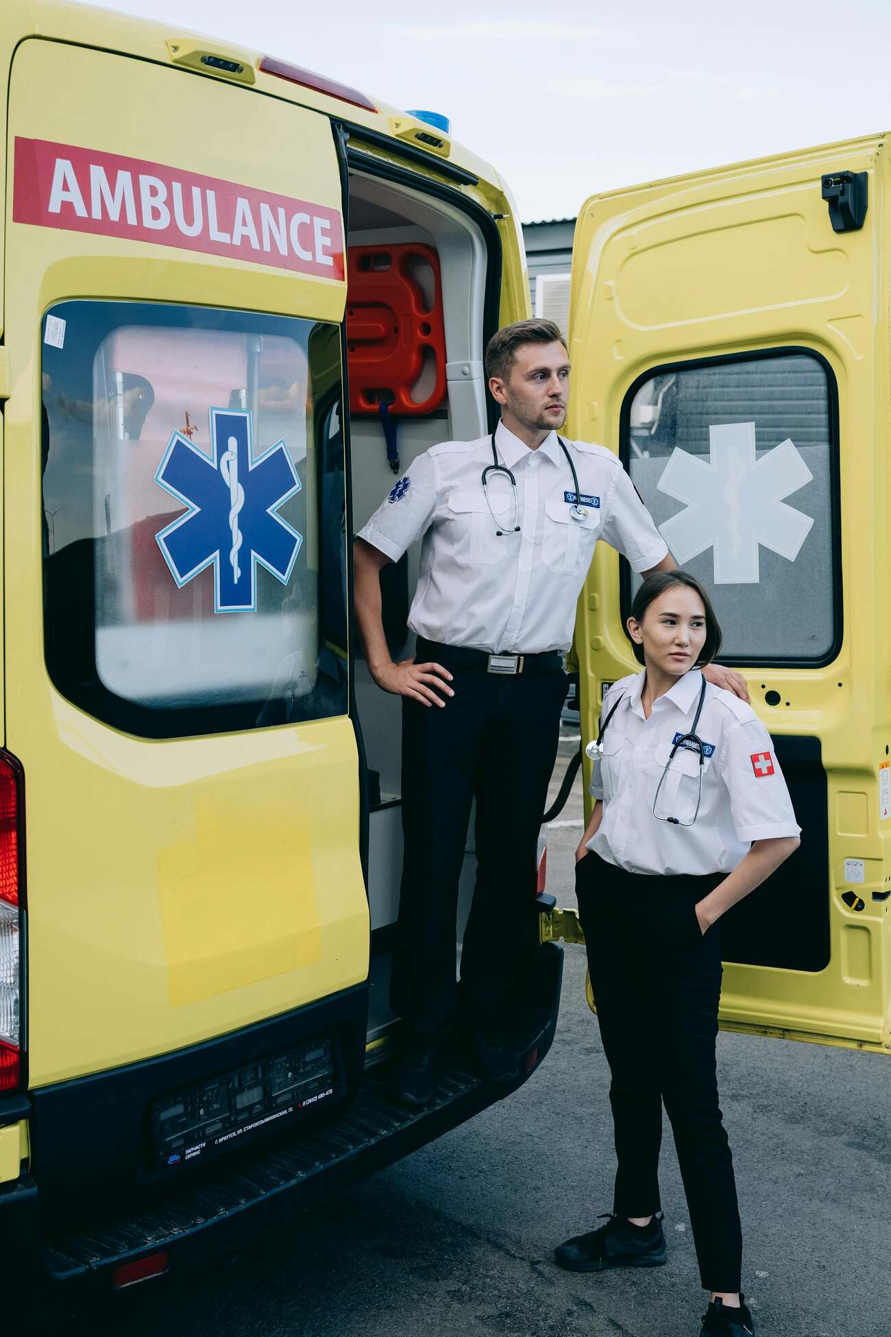 Two paramedics standing outside of an ambulance